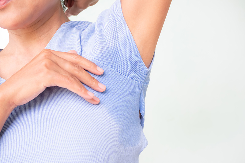 Woman experiencing excessive sweating in underarm area