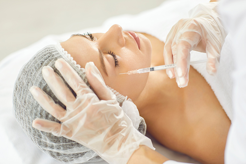 A woman receiving a cosmetic dermatology injectable treatment.